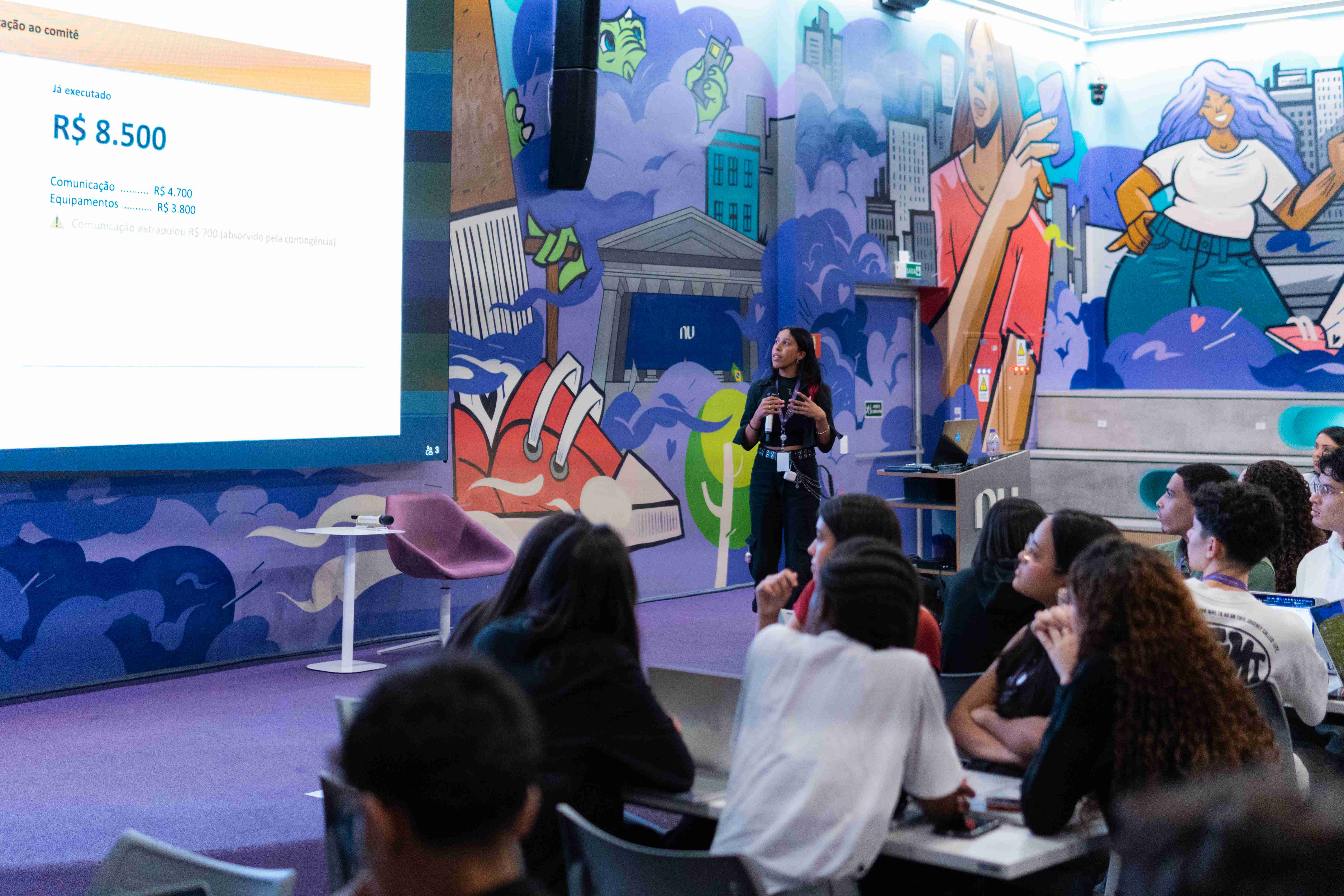 Aprendiz apresentando para colegas no ambiente do Nubank